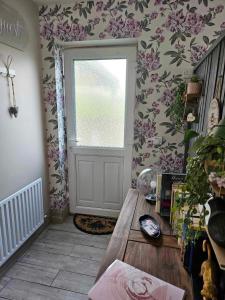 邓多克Croí Beag Luxury Studio的墙上有一扇鲜花门的房间