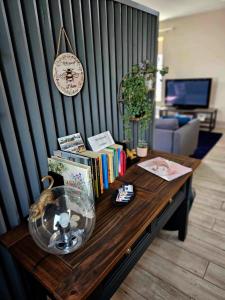 邓多克Croí Beag Luxury Studio的一张木桌,墙上挂着书籍和时钟