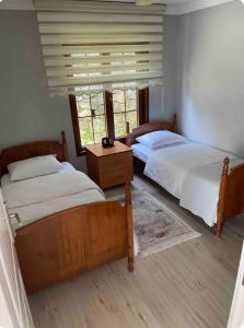 阿克恰阿巴德Trabzon saklı villa的一间卧室设有两张床和窗户。