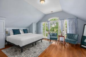 CowansvilleManoir Sweetsburg的一间卧室配有一张床和两张蓝色椅子