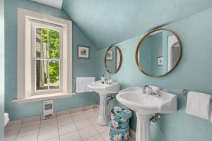 CowansvilleManoir Sweetsburg的蓝色的浴室设有两个盥洗盆和镜子