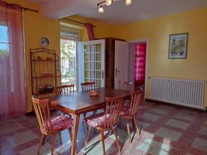 Le Grand VireyLe Nid des Tourterelles的一间带木桌和椅子的用餐室