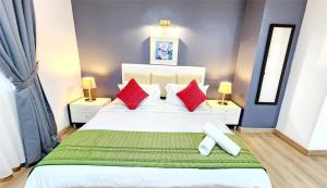 吉隆坡吉隆坡假日广场公寓的卧室配有带红色枕头的大型白色床
