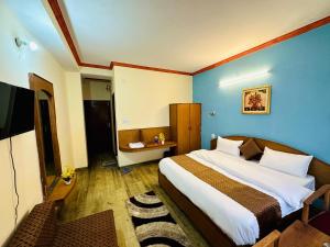 西姆拉Hotel Tara Regency - A family Hotel的一间卧室设有一张蓝色墙壁的大床