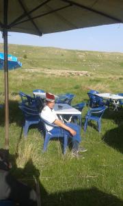 Çiftlik otel的坐在田野桌子上的男人