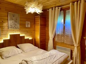 Saint-Laurent-du-JuraChalet des Moineaux的木制客房内的一间卧室,配有一张床