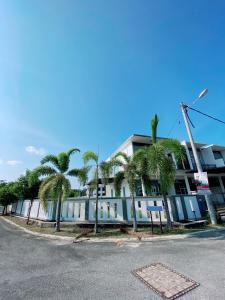 瓜拉丁加奴Homestay 2 Tingkat Kuala Terengganu的街道前方有棕榈树的建筑