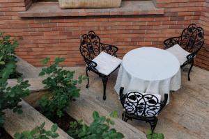 阿尔巴尤利亚卡罗琳酒店的一张桌子和两把椅子,上面有白色的桌布
