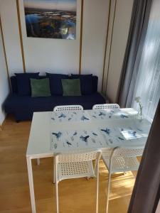 米利奇Szpak i Gil - domki letniskowe w Dolinie Baryczy的一张带椅子的白色桌子和一张蓝色的沙发