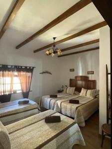 La Puerta de SeguraLa magnolia的一间卧室设有两张床和天花板
