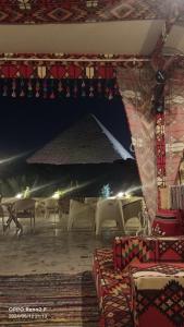 开罗Crystal pyramid inn的夜间带桌椅的帐篷