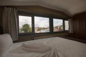 伊斯坦布尔麦肯特酒店的一间卧室设有一张床和一个大窗户