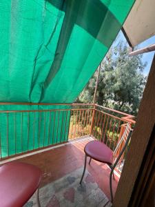 Piossascoking's house的阳台配有两把椅子和绿油布
