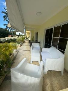 博卡奇卡Las Palmeras by Graziano的庭院配有2张白色沙发和1张桌子