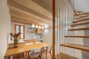 皮兰BAY BREEZE Holiday house in Piran的厨房以及带木桌和椅子的用餐室。