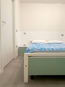 PierisNon ti scordar di me #2的一间卧室配有一张白色的床和蓝色的毯子