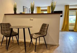 KinheimVonMos Moselblick Apartments的桌子和两把椅子,旁边是柜台