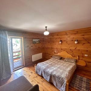 亚列姆切Kipreya的一间卧室设有一张床和木墙