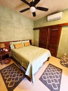 科苏梅尔Casa vishami的一间卧室配有一张床和吊扇