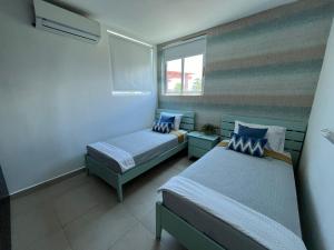 普拉亚布兰卡Playa Blanca Beach Rentals的一间卧室设有两张床、一张沙发和一个窗口