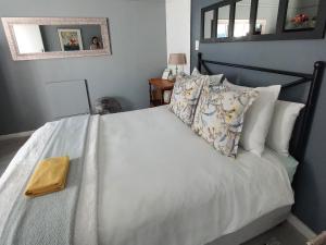 斯泰伦博斯Peony Luxury Room with Wifi and own entrance的卧室配有带枕头和镜子的白色床