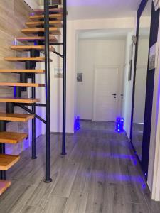 努马纳La Fenice 40的铺有木地板,配有蓝色灯光的客房的楼梯