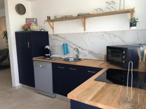 勒迪亚芒T3 Proche des plages - Calme - Parking privé的厨房配有水槽和微波炉