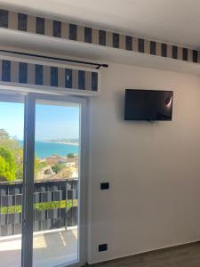努马纳La Fenice 40的客房设有1扇带平面电视的滑动玻璃门