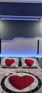 努马纳La Fenice 40的一间卧室配有一张带红色心枕的床