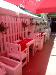 希典Familia Fantastiko的粉红色帐篷下一排白色的桌椅