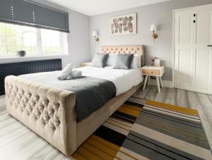 雷纳姆Beautiful Newly Renovated House in Rainham Essex的一间卧室配有一张大床和软垫床头板