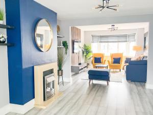 雷纳姆Beautiful Newly Renovated House in Rainham Essex的客厅设有蓝色的墙壁和镜子
