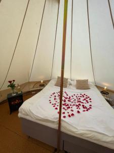 玛丽港Glamping Tent Mariehamn的帐篷里一张有红色鲜花的床