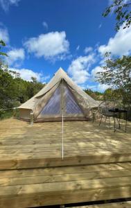 玛丽港Glamping Tent Mariehamn的木甲板上的帐篷,配有桌子