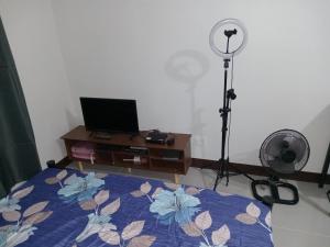 Lapu Lapu CityHaven of Deities Property Rental的一间卧室配有一张床和一张带风扇的书桌