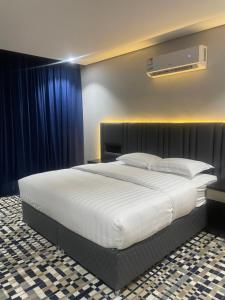 艾卜哈قمم بارك Qimam Park Hotel 4的卧室配有一张带蓝色窗帘的大型白色床