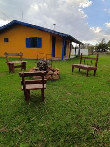拉热斯Casa Amarela的坐在黄色建筑前面的三张长椅