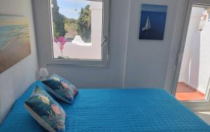 萨阿拉德洛斯阿图内斯ATLANTERRA PUEBLO的一间卧室配有一张蓝色的床和窗户