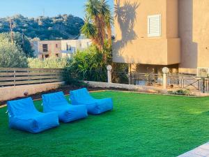 斯塔里斯Astali Villa的绿色草坪上的蓝色椅子