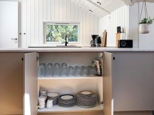 北内伯尔Holiday home Nørre Nebel CXXV的厨房配有带盘子和瓶子的架子