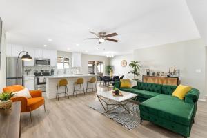 凤凰城NEW l Modern l Amazing Pool-BBQ- Short & Long stays的一间带绿色沙发的客厅和一间厨房