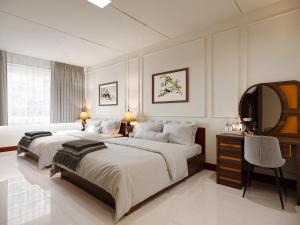 胡志明市Baglioni Signature的一间大卧室,配有两张床和镜子