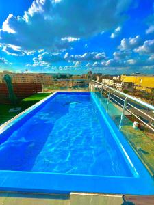 伊尔比德رويال جروب اربد Royal Group Hotel的一座建筑屋顶上的蓝色大游泳池