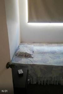 加拉加斯Seguridad y Tranquilidad的窗户客房内的小床