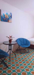 塔拉波托hotel Suyay Lodge Tarapoto的一间设有两把椅子、一张桌子和一张床的房间