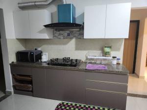 SiruseriApartment in IT SIPCOT OMR的厨房柜台配有炉灶和微波炉