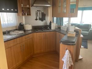 GreatstoneRomney Sands holiday home的厨房配有木制橱柜和台面