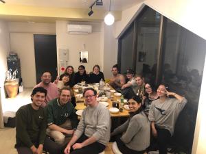 东京MAKOTO GUESTHOUSE -Enjoy your stay-的一群人坐在桌子旁