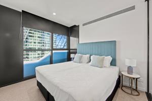 布里斯班Fortitude Valley Apartments by CLLIX的卧室设有一张白色大床和一扇窗户。