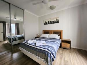 朱里恩湾Unit 26 Seafront Estate的一间卧室配有一张床和一面大镜子